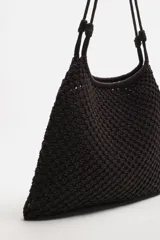 Bolso tipo shopper color marrón oscuro, confeccionado en tejido trenzado de algodón con diseño de macramé. Tiene dos asas de hombro y cierre fruncido en el compartimento principal.