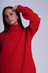 Sweater rojo de punto trenzado con cuello alto.