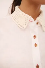 Camisa blanca de lino con cuello clásico y puños con detalle de crochet.