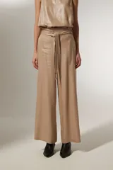 Pantalón ancho de tiro alto color beige metalizado, confeccionado en lino y viscosa, con lazo para ajustar en la cintura.