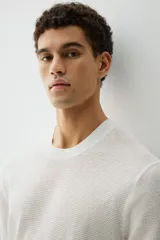 Remera blanca de algodón con tejido de punto calado, cuello redondo y corte estándar.