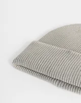 Gorro de lana tejido en punto canalé color gris claro con efecto desgastado.