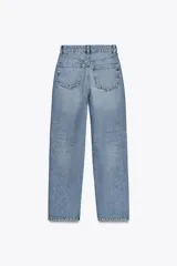 Pantalón de jean celeste de tiro alto, corte mom fit, largo regular y roturas en las rodillas.
