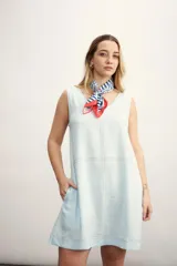 Vestido corto color negro, sin mangas, con escote en V y bolsillos laterales.