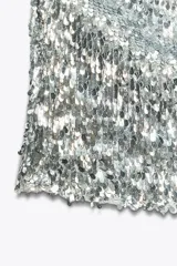 Top plateado con lentejuelas, cuello halter ajustable con lazada y forro interior de tul.