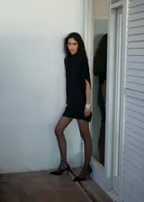 Vestido corto negro con diseño evasé y mangas asimétricas.