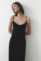 Vestido largo negro de escote fluido y tirantes finos ajustables.