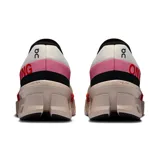 Championes de running On Cloudmonster 2, color blanco con detalles en negro, rojo y rosa.
