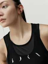 Musculosa deportiva negra con logo estampado en el pecho y tejido mesh en la parte superior.