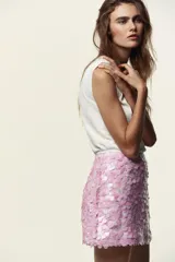 Minifalda rosada cubierta de lentejuelas, con forro interior y cierre lateral oculto.