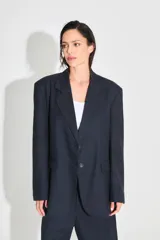 Saco sastrero oversize confeccionado en sarga color azul marino, con estampado de doble R con diseño animal print en la espalda. Tiene botones frontales, bolsillos delanteros y está forrado con tafeta a tono.