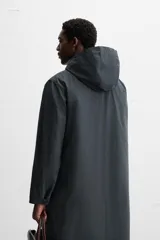 Parka relaxed fit confeccionada en tejido técnico repelente al agua. Interior acolchado desmontable. Cuello solapa con capucha desmontable. Manga larga con puño ajustable con botones a presión. Bolsillos de vivo en cadera. Bajo con abertura central en espalda. Cierre frontal con cremallera oculta por solapa con botones a presión. Chaleco interior acolchado y desmontable con cuello pico y manga sisa.