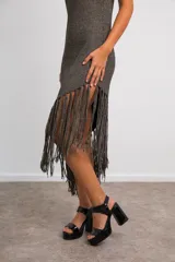 Vestido midi de lurex metalizado color dorado, sin mangas y con falda asimétrica con flecos largos.