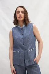 Chaleco color crema de lino, con cuello mao, cierre frontal con botones y bolsillos ojal a contratono.