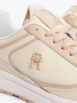Zapatillas Tommy Hilfiger color beige con detalles en dorado. Confeccionadas en piel con monograma TH en la lengüeta y lateral. Suela de goma blanca y beige.
