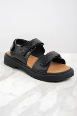 Sandalias negras con textura símil piel de cocodrilo, con ajuste de velcro y suela track.