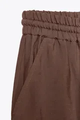 Pantalón jogger marrón de tiro alto con cintura elástica ajustable con cordones, bolsillos delanteros y puños elásticos en los tobillos.