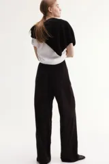 Pantalón culotte negro de viscosa con cintura elástica y cordón ajustable. Tiene bolsillos laterales y corte amplio.