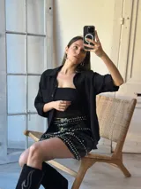 Minifalda negra de lentejuelas con tachas plateadas y cintura elastizada.