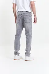 Jean celeste de corte slim, tiro medio y con presillas para cinturón.