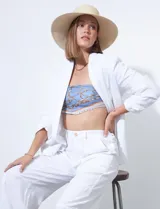 Blazer blanco de lino con cuello con solapa, bolsillos sastre y mangas fruncidas.