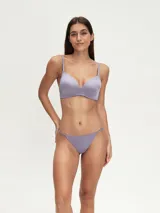 Conjunto de ropa interior color lila, compuesto por un soutien con breteles regulables y una tanga con detalle de puntilla.