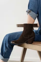 Bota corta de cuero vacuno color negro, con punta metálica plateada, taco de 7cm y suela de caucho antideslizante.