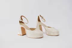 Zapato de tacón alto color crema, con plataforma y pulsera al tobillo.