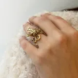 Anillo de bronce color dorado con forma de panal de abeja y una abeja en el centro.