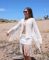 Pollera corta tejida a mano en crochet color blanco, con detalle de flecos en el ruedo.