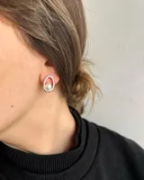 Par de aros de plata 950 con diseño orgánico o irregular, cada uno engarzando una perla blanca en el centro.