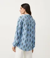 Camisa celeste de viscolino con estampado floral, cuello camisero y mangas largas.