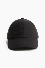 Gorra negra de lino y algodón con ojales bordados en la parte superior y trabilla ajustable con hebilla de metal atrás. Cinta antitranspirante de algodón.