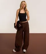Pantalón wide leg color marrón chocolate, de corte sastrero con cintura elástica y lazo ajustable.