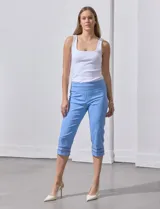 Pantalón capri blanco de gabardina elastizada con bolsillos simulados, pretina ancha, corte recto y detalle de puntilla en el ruedo.