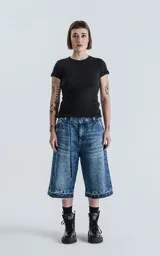 Bermuda larga de denim con calce oversize, desgaste y ruedo desflecado.