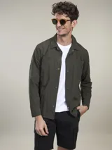 Camisa verde militar de manga larga con cierre de botones, cuello clásico y dos bolsillos frontales con solapa.