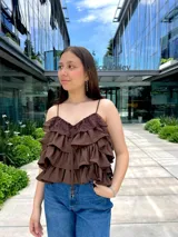 Blusa color amarillo manteca con tirantes finos, escote en V con detalle de encaje y volados en el frente.