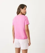 Remera rosa de algodón con cuello redondo y lunares blancos.
