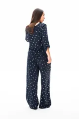 Mono azul con estampado de hojas doradas, mangas 3/4 y pantalón palazzo.