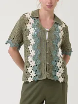 Chaleco tejido a crochet con diseño de flores en tonos beige y crudo, con cuello camisero y cierre frontal con botones de madera.