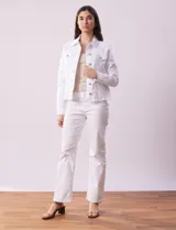 Campera de jean blanca, marca Baccini, con cuello solapa, bolsillos delanteros, abertura central con botones metálicos y terminación desflecada en el ruedo.