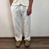 Pantalón de lino color beige, de corte recto, con cintura ajustable con cordón.
