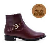 Bota corta de cuero negro con hebilla lateral y taco bajo.