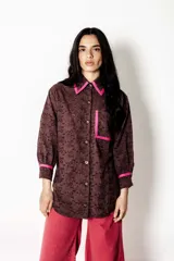 Camisa marrón con bordado calado, cuello clásico y detalles en fucsia en cuello, bolsillo y puños.