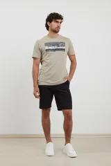 Remera color caqui con estampado rectangular de una foto en blanco y negro en el pecho.
