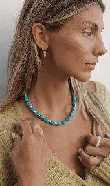 Collar corto de cuentas facetadas color turquesa con separadores dorados.