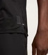 Remera deportiva negra de poliéster y elastano, con tecnología Dry, cuello redondo, manga corta y estampa jacquard.