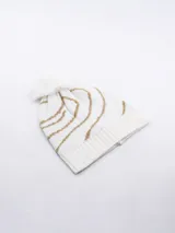 Gorro de lana blanco con diseño de líneas onduladas color dorado y pompón blanco en la parte superior.