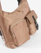 Cartera hobo marrón, convertible en mochila, con múltiples bolsillos y cierre en compartimento principal.